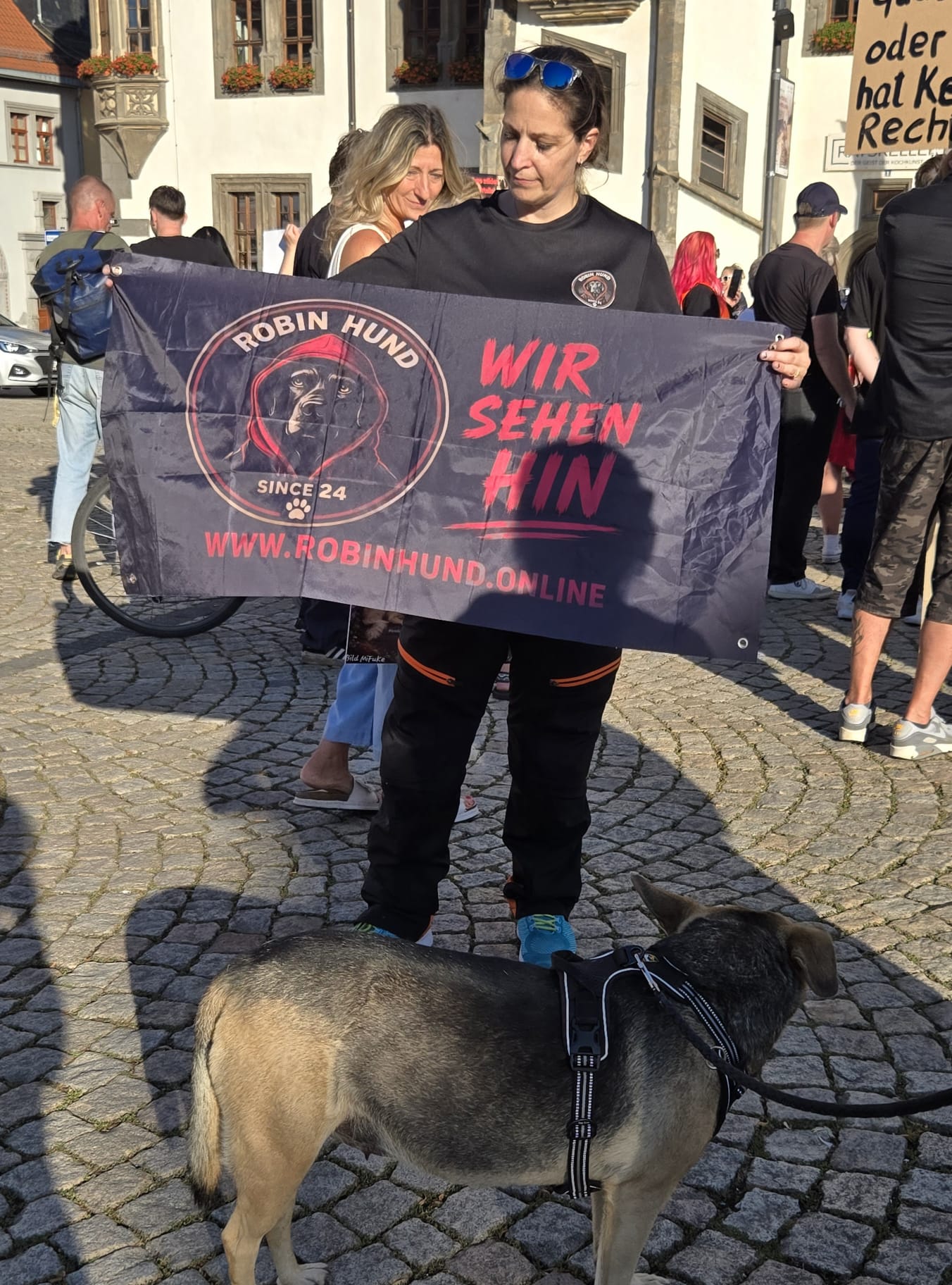 Robin-Hund-Banner „Wir sehen hin“ bei einer Mahnwache